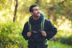 a man reflects on a walk in the woods about how sober living helped him strengthen his recovery goals